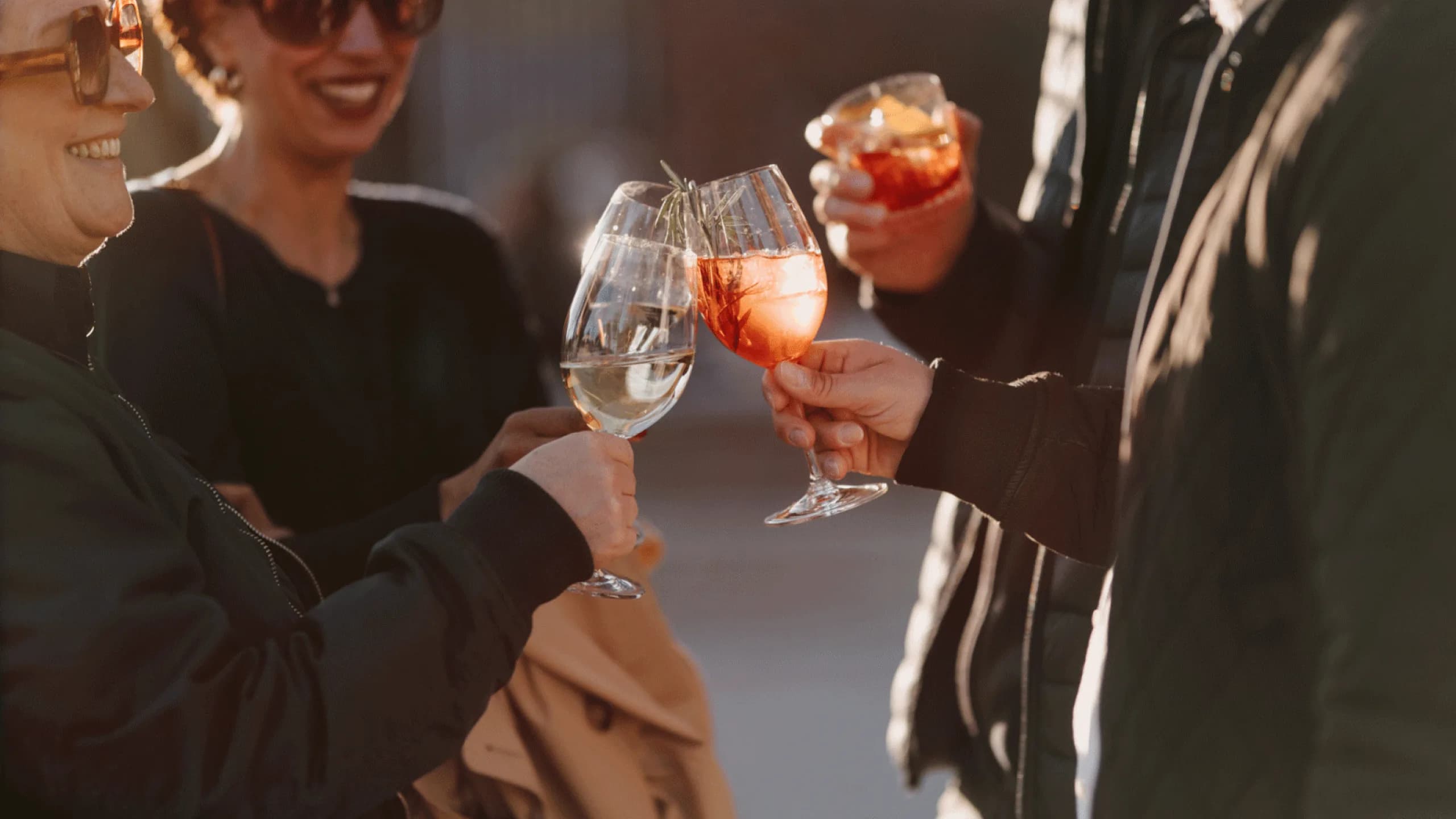 Gäste stoßen mit Drinks im Außenbereich an